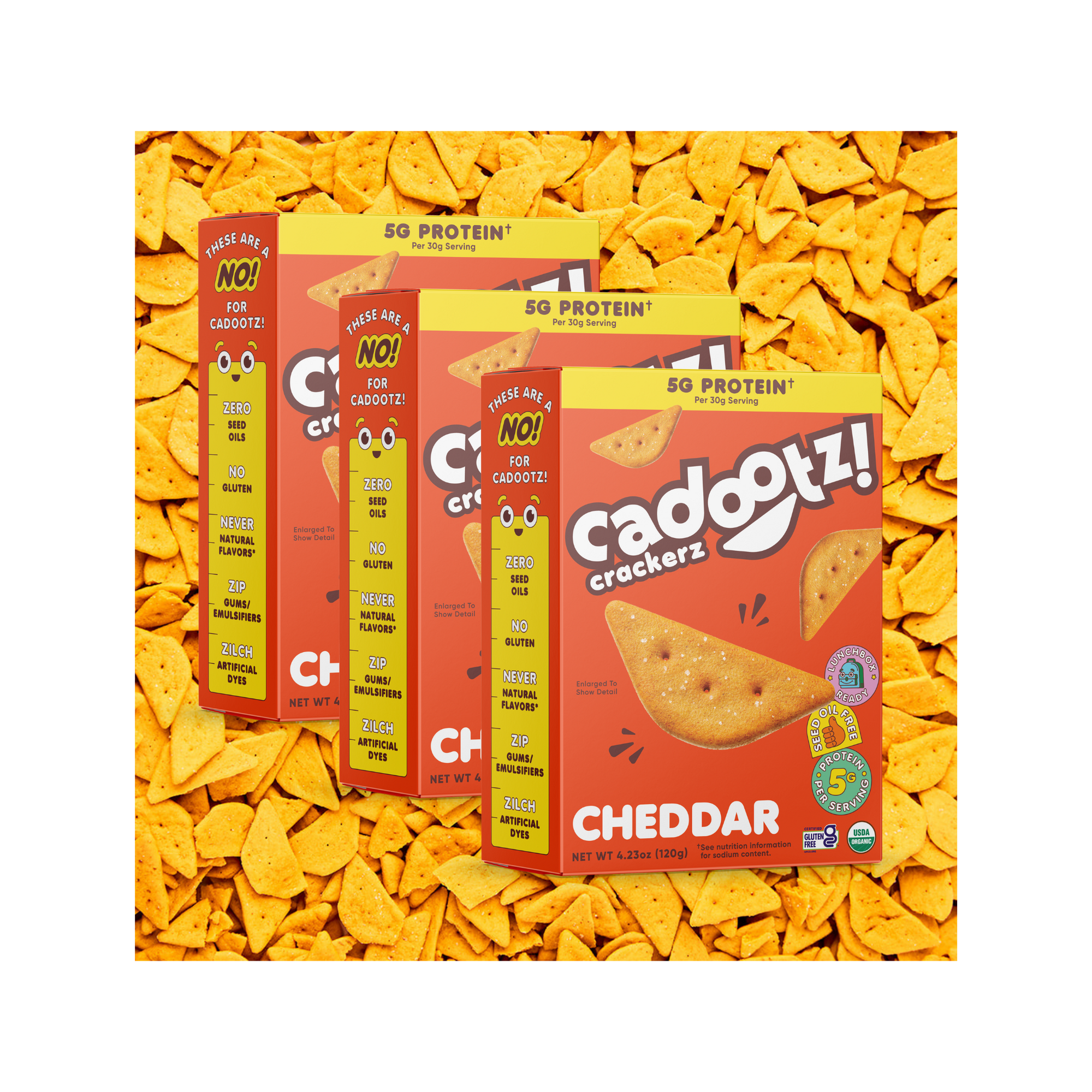 Three cadootz! cheddar cracker box surrounded by yellow cracker pieces in the background